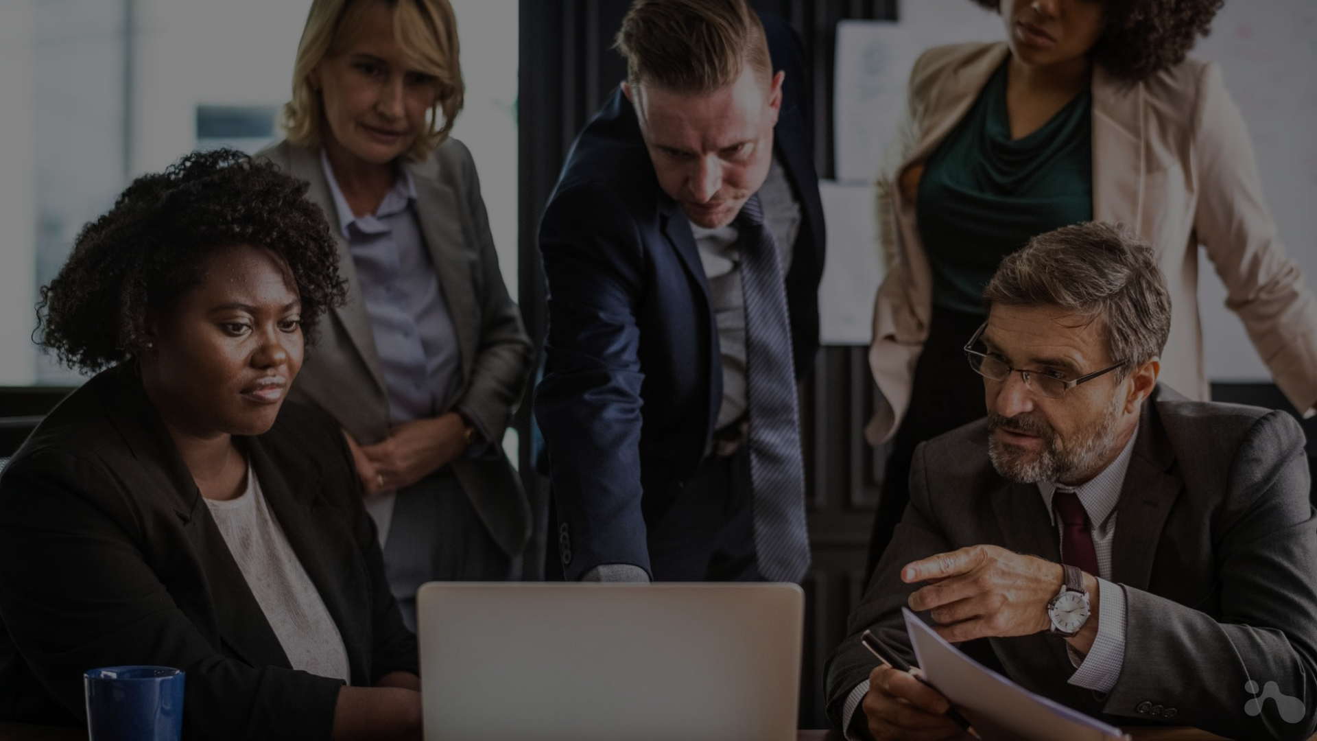 Diverse group of businesspeople collaborating over a laptop. 